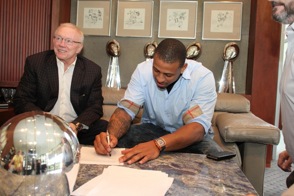 Greg Hardy assina o contrato ao lado de Jerry Jones. Foto: DallasCowboys.com